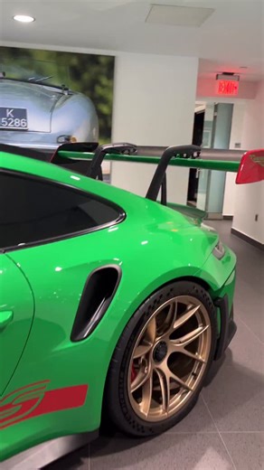 The 2023 Porsche 911 GT3 RS (78216) is an extraordinary example of Porsche’s ultimate track-focused road car. Finished in striking Python Green with red decals, this GT3 RS is immediately recognizable on the road or track, with its aggressive aerodynamic enhancements, wide rear haunches, and signature fixed rear wing designed for maximum downforce and high-speed stability. The cabin combines luxury with motorsport functionality, featuring black leather and Race-Tex upholstery accented by GT Silv
