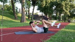 athlete guy doing bicycle exercise for abs muscles outdoor, training