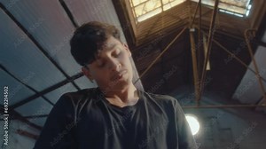 Young professional sportsman doing head rolls and wrist circles exercise during warm up before training in the gym. Zoom shot