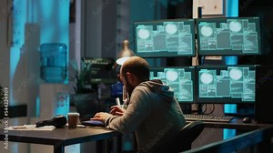 Young happy hacker celebrating coding achievement at night, feeling pleased about hacking system. Smiling IT programmer with hidden identity feeling good about success and cyber win.