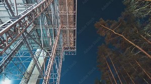 Beautiful night time lapse video under Snow Arena metal construction beams with starry night sky in the background. Shot during winter time.