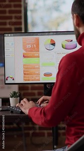 Vertical video: Sales consultant using e commerce statistics on computer monitor to develop financial growth and business development. Manager working with data analysis diagrams for research. Tripod