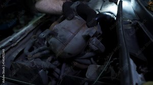 Mechanic removes, unscrews the coolant expansion tank.