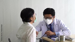 asian doctor using stethoscope to exam heart sound of the senior patient who visit at clinic in hospital. healthcare and medical concept