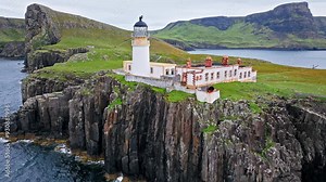 Aerial view of Lighthouse on a rocky cliff-top overlooking a causeway and the coastline in Scotland. Travel destination, tourist attraction landmark of Scottish Neist Point Lighthouse on Isle of Skye.