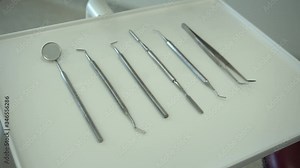 Set of dentist tools on white background: dentist mirror, forceps curved, explorer curved, dental explorer angular and explorer curved with chip. Dental Hygiene and Health conceptual image
