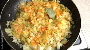 Cabbage is stewed with wet mushrooms in a frying pan. View from above. Cooking master class. Step-by-step video recipe for making stewed cabbage.
