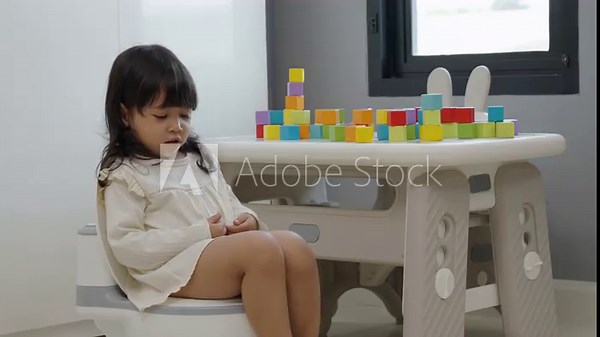 toddler girl learning sit on toilet wc seat at home. child being potty trained
