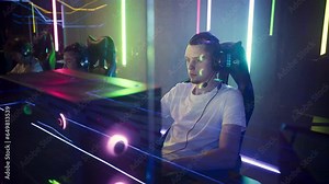 Gamer Guy Playing Digital Computer Games On Modern Powerful PC With RGB Lights. Gamer Guy Wearing Gaming Headset For Team Communication Plays On PC. Gamer Guy Playing On PC At ESports Cyber Club