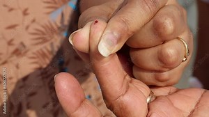 At home doing a finger prick test for blood sugar. Drawing blood using Lancing Device