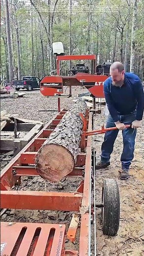 Woodcutting Precision: Man Operates Machinery to Cut Logs
