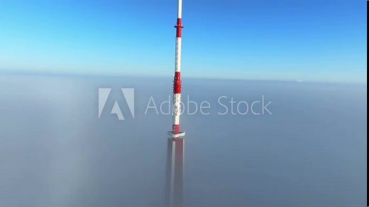Aerial view of the Riga Radio and TV Tower in Riga, Latvia - the tallest tower in the European Union on a cloudy winter morning. Tower partly covered in thick clouds.