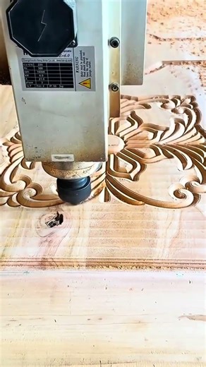 The process of carving intricate floral patterns on wooden surface using computerized router machine