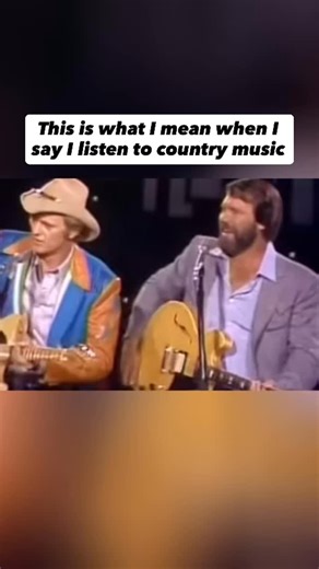 Country Music News on Instagram: "Follow us @OutlawCountryNews for more posts like this 🤠🤝 Glen Campbell and Jerry Reed performing Guitar Man live in the late 1960s was a rare meeting of two of the most respected guitar minds in country music. Reed wrote the song and originally recorded it, but Campbell’s version helped take it to the top of the charts and turn it into a defining hit of the era. Seeing them share the stage brought the song full circle and highlighted the mutual respect between