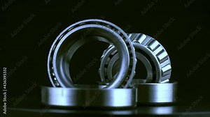 Cyclic seamless video with bearings rotating on a turntable on a black background. The two bearings rotate around their axis. Mechanism concept and equipment. Close-up, macro.