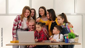 Happy and free teenagers, browsing something on the computer, chatting and hugging all together.