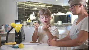 mom helps son boy do homework for school the tutor helps the child to learn