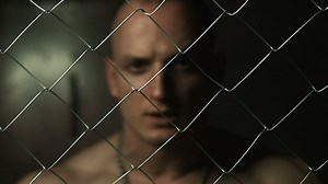 Angry prisoner behind a wire fence - Free Stock Video
