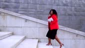African American confident businesswoman walking on stairs.