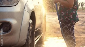 Asian senior female washing Family car with water tube,Slow motion shoot with ,120 Fps By Sony A6300 .
