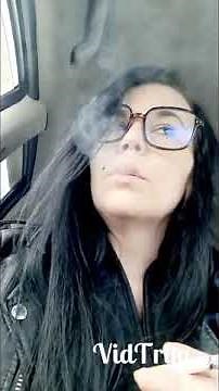 woman smoking Newport 100 with glasses and leather jacket
