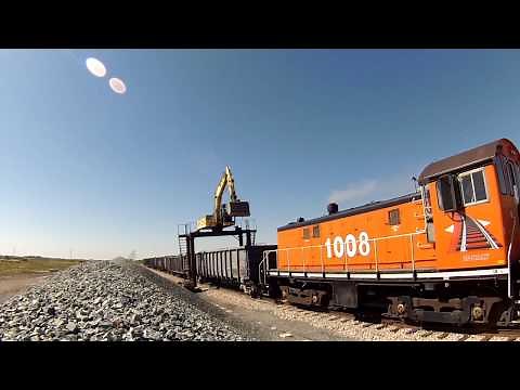 Straddle Excavator Unloading Gravel Railcars