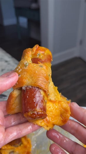 Warm, fluffy rolls stuffed with smoky sausage and gooey cheddar, then brushed with rich garlic butter. Simple ingredients, BIG flavor. Perfect for parties, brunch, or a cozy snack! #SmokedSausage #CheddarRolls #GarlicButter #EasyRecipes #ComfortFood #BakingMadeSimple #SavoryRolls #HomemadeDelicious #PartySnacks #BrunchBites #FoodieFavorites | Savory Spoon