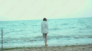 Beautiful summer woman walking in sea water with waves. Freedom and paradise concept