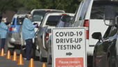 Rack Focus Shot of a "COVID-19 Drive-Up Testing" Sign in the...