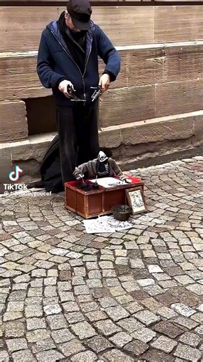 A marionette puppet draws with lifelike control by a street performer