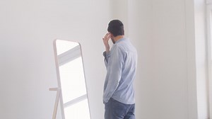 Dark haired man staring at himself in the mirror Free Stock Video Footage