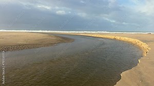 A waterway meandering along the Zahara coastline in Spain, showcasing the natural erosion process.