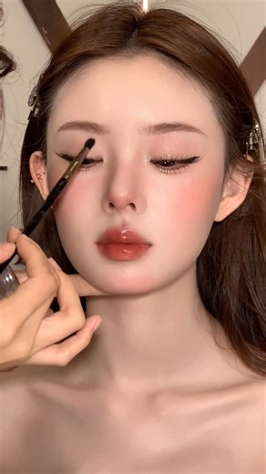 Mina Studio on Instagram: "A classic-meets-modern editorial makeup look emphasizing sharp features and refined elegance. The skin is perfected with a smooth matte finish, allowing bold winged eyeliner and defined lashes to stand out, creating a deep, captivating gaze. Cool-toned blush placed high on the cheeks and a glossy wine-red lip add a touch of luxury and power. The overall look feels high-fashion, ideal for editorial shoots and statement cover visuals."