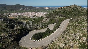 Aerial view of uphill and downhill rides at Vall de Ebo pass.Professional cyclist training in the mountains of Spain.Сyclists ride on a winding road in the mountains.Pego,Alicante,Spain.