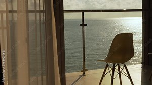 Beautiful Sea View Terrace Window at Sunset. Sea in the Rays of the Sun Sky and Clouds. Chair on Balcony with Relaxing Ocean View. Relax, Beauty, Vacation.