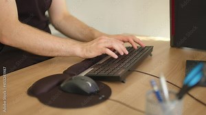 man typing on black keyboard and hitting it at the end. angry worker in office or home office. Close up of hands working at a desk.