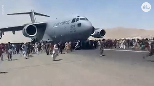 Desperate Afghans cling to U.S. military airship as it takes off from Kabul airport
