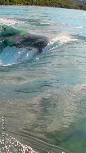 Powerful currents surge around rocks and crash in Rio Futaleufu. White water sparkles beneath the Patagonian sky, a majestic and thrilling aquatic display.