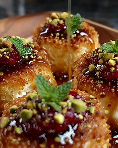 Pistachio-Crusted Brie Bites with Raspberry Honey Glaze Ingredients: 4 oz (115 g) Brie cheese, cut into small cubes ¼ cup (30 g) shelled pistachios, finely chopped 12 mini phyllo cups or puff pastry squares (about 75 g) 2 tbsp raspberry preserves (30 g) 1 tbsp honey (15 ml) Optional: fresh thyme or mint leaves for garnish Directions: Preheat oven to 375°F (190°C). Place phyllo cups on a parchment-lined baking sheet. Roll each Brie cube in the finely chopped pistachios to coat evenly. Place each 
