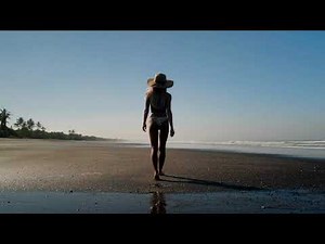 Wet Look: Sexual Woman on Beach of Ocean Dressed in Bikini Back View