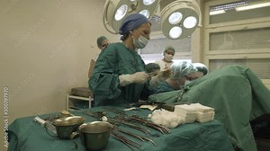 Medical team of surgeons and nurses during gynecological operation in operating theater.
