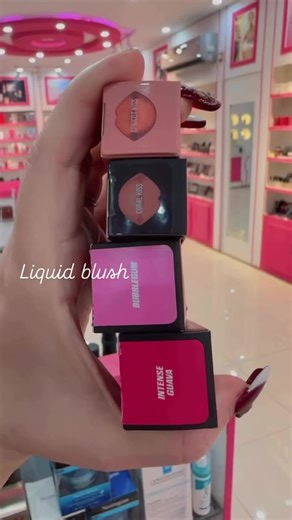 Huda Beauty Liquid Blushes, likely in the shades 'Coral Kiss' and 'Intense Guava'. It is a lightweight liquid blush with buildable pigments and finely milled micro-pearls for a soft-focus, high-impact glow. The formula is described as creamy and easy to blend, offering a semi-matte finish. It contains skin-loving ingredients like hyaluronic acid powder and coconut extract, making it comfortable, hydrating, and lightweight with major staying power. The blush can be applied with a doe-foot applica