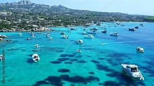 Aerial Drone View over Cala Serena at Caprera Island, Sardinia. Bay Full of Boats and Luxury Yachts. Cristal Clear Turquoise Water. Rocky Coast.