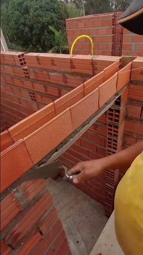 the bricklayer teaches how to pass the gutter with iron and lattice on the lintel and counter lin...