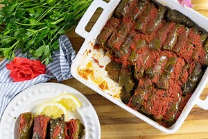 Greek Stuffed Grape leaves in Tomato Sauce: Dolmadakia me Domata These grape leaves are stuffed with rice, meat, and herbs and then baked in a light tomato sauce. This dish is light, aromatic, and very delicious. Traditionally, it is made vegetarian with just rice and herbs and commonly served in Northern Greece. Perfect for a family dinner and elegant enough for a party. Print this recipe here: https://www.dimitrasdishes.com/greek-stuffed-grape-leaves-in-tomato-sauce-dolmadakia-me-domata/ | Dim