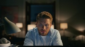 Attentive man watching pc at home closeup. Worried freelancer trying understand problem at evening apartments. Remote work guy reading desktop computer checking mistakes with focused face alone