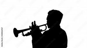 Silhouette African american musician playing the trumpet expressively.