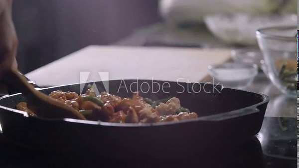 The chef prepares an Asian-inspired dish, combining fried chicken with a crispy golden crust and a sweet and sour sauce, along with vegetables. Extreme close-up. Slow motion. 4k