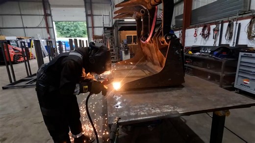 Excavator bucket cutting and repair in fabrication workshop