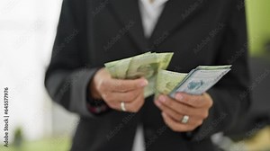 Young beautiful hispanic woman business worker counting chilean pesos at office